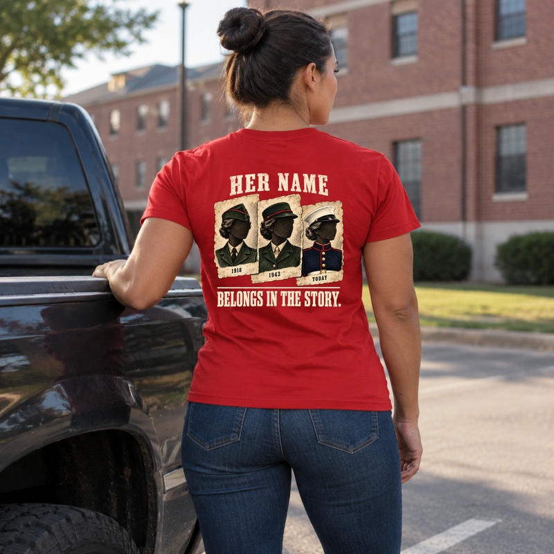 Woman wearing red Her Name Belongs in the Story Marine t-shirt standing by pickup truck