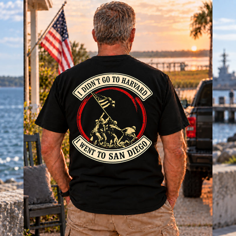 Man wearing a black San Diego custom year veteran T-shirt, back print view, at sunset by the water