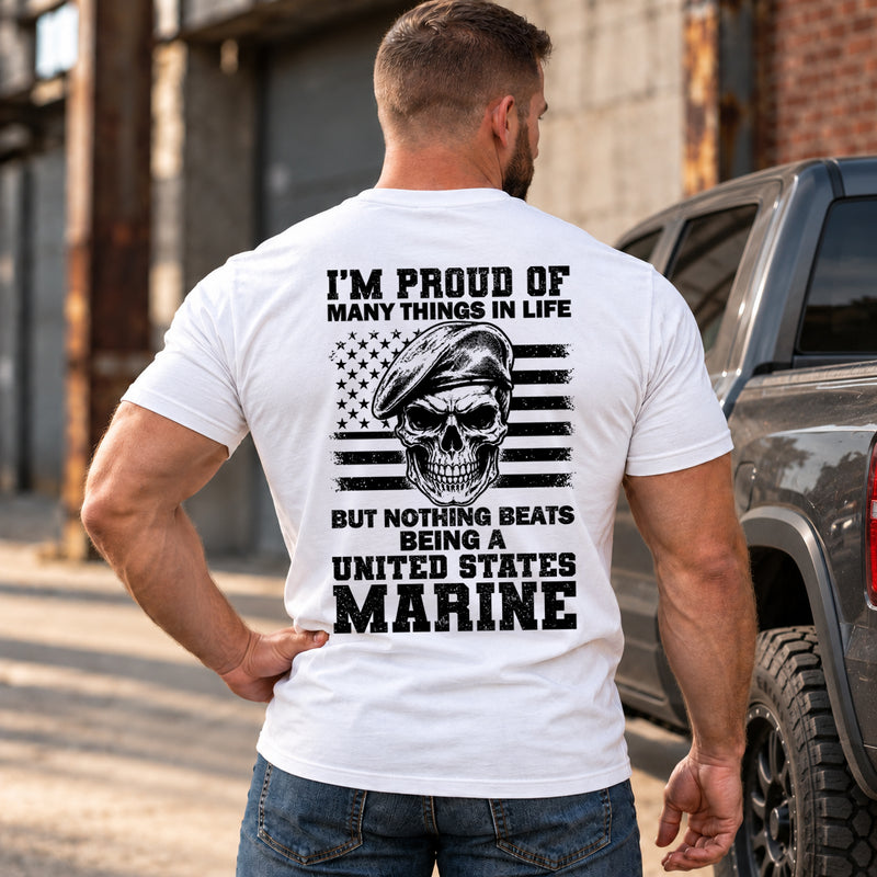 Man wearing a white Being A Marine custom year veteran T-shirt, back print view, Industrial street beside a pickup truck