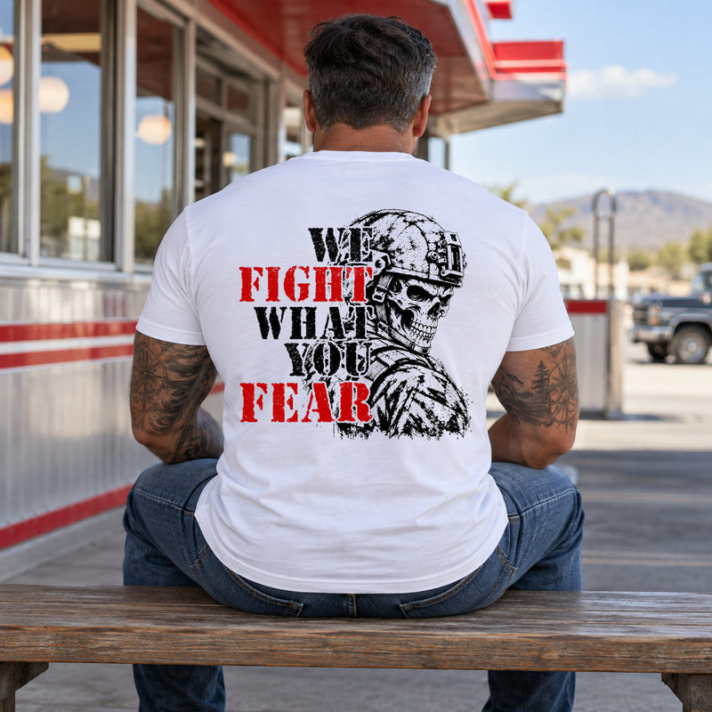 Man wearing a white We Fight What You Fear custom year veteran T-shirt, back print view, bench outside a roadside diner