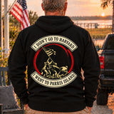 Man wearing a black Parris Island veteran hoodie, back print view, at sunset by the water