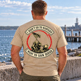Man wearing a sand San Diego custom year veteran T-shirt, back print view, on the waterfront