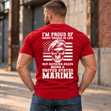 Man wearing a red Being A Marine custom year veteran T-shirt, back print view, Industrial alley with weathered brick walls