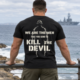 Man wearing a black Kill The Devil custom year veteran T-shirt, back print view, seaside railing with warship offshore