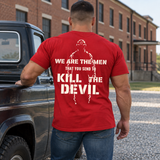 Man wearing a red Kill The Devil custom year veteran T-shirt, back print view, beside pickup truck near brick building