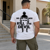 Man wearing a white Kill The Devil custom year veteran T-shirt, back print view, stone building courtyard with stairs