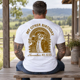 Man wearing a white My Other Birthday custom year veteran T-shirt, back print view, rustic porch overlooking rolling farmland