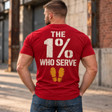 Man wearing a red The 1% veteran T-shirt, back print view, brick warehouse alley
