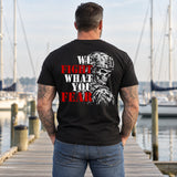 Man wearing a black We Fight What You Fear custom year veteran T-shirt, back print view, wooden dock at a sailboat marina