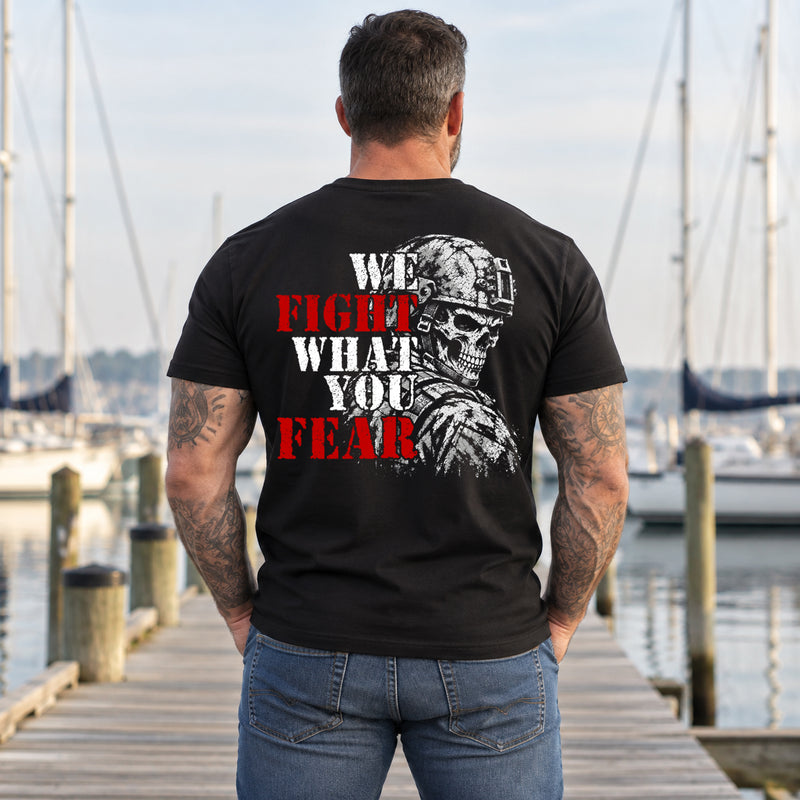 Man wearing a black We Fight What You Fear custom year veteran T-shirt, back print view, wooden dock at a sailboat marina