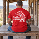 Man wearing a red We Run Towards the Gunfire custom year veteran T-shirt, back print view